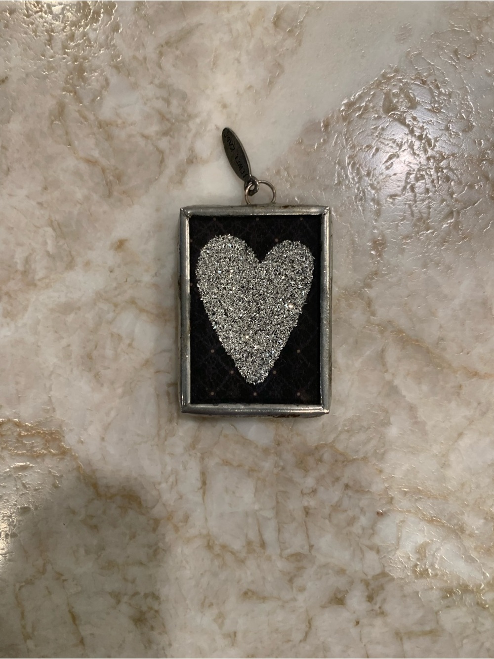 Silver Glitter Heart Pendant on Black Background